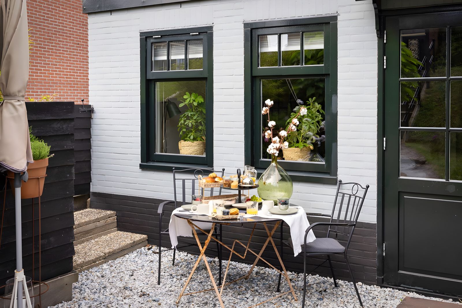 Ontbijttafel voor de B&B, wit huis met donkergroene kozijnen